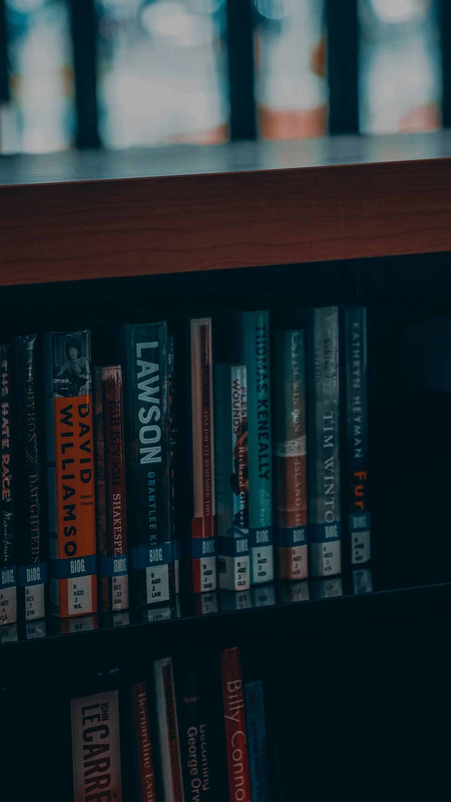 a bookshelf filled with lots of books next to a window